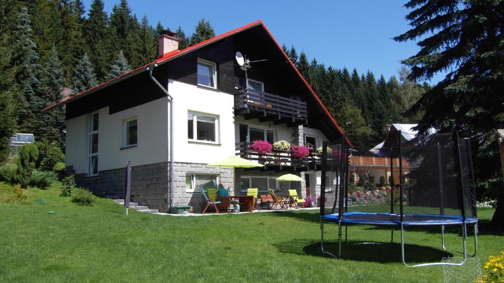 ein Haus mit Spielplatz im Hof in der Unterkunft Pension Arabela in Harrachov