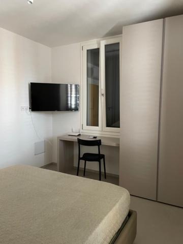 a bedroom with a bed and a desk with a chair at Domus Mazzini in Cattolica