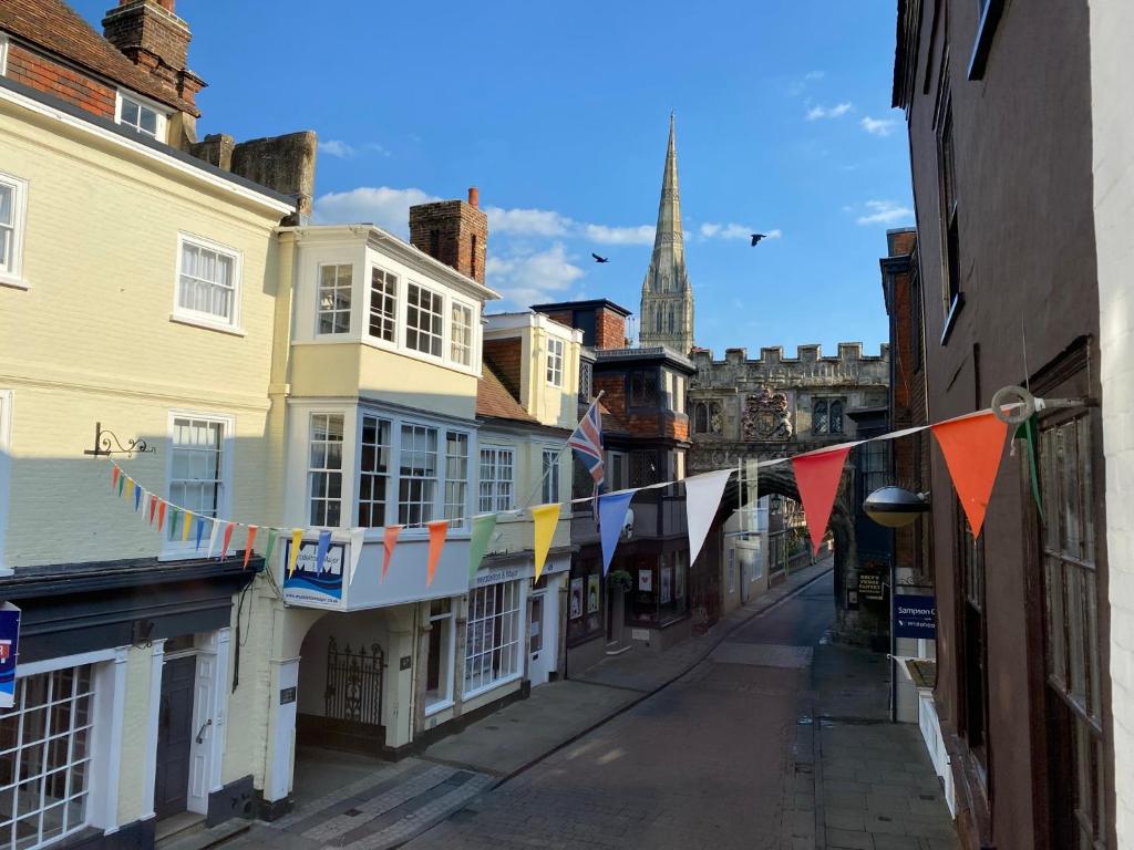 a street with flags and buildings in a city at Purlins Holiday Apartment in Salisbury