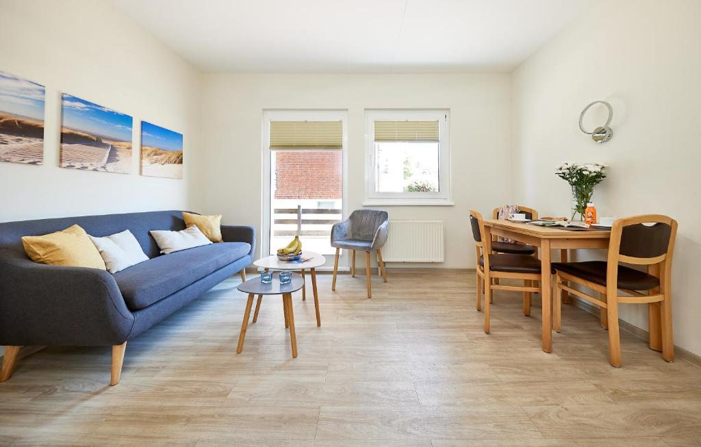 ein Wohnzimmer mit einem blauen Sofa und einem Tisch in der Unterkunft Haus Pamir - Fewo 22 in Cuxhaven
