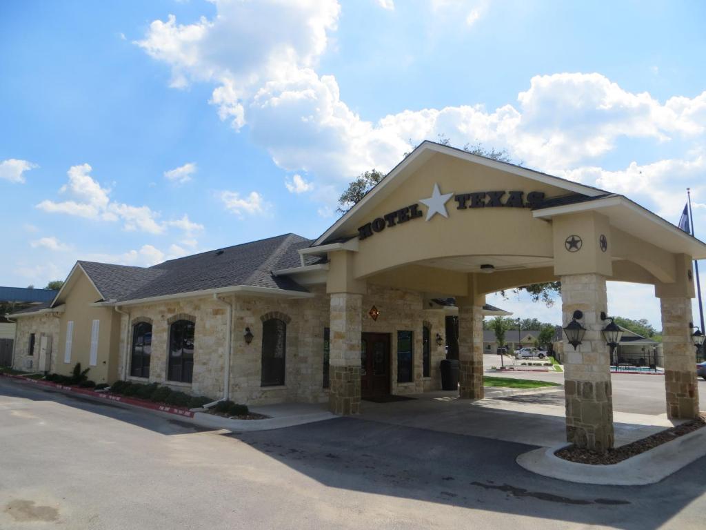 a building with a sign on top of it at Hotel Texas Cuero in Cuero