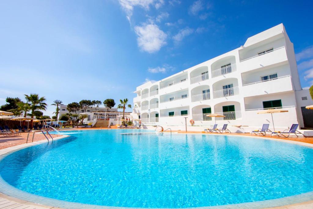 a large swimming pool in front of a building at Gavimar Ariel Chico Hotel and Apartments in Cala d´Or