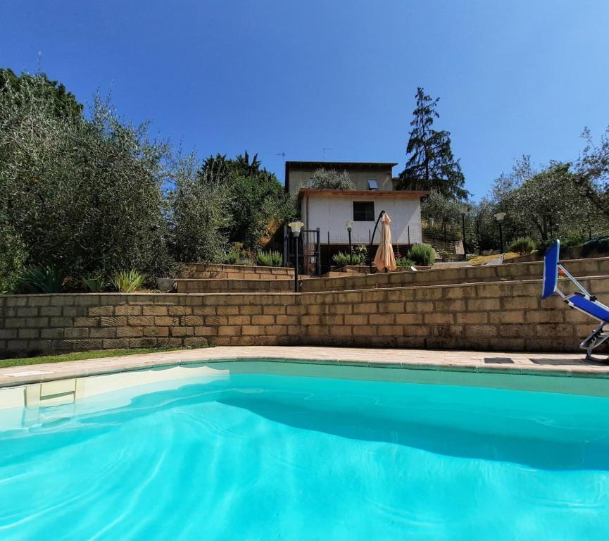 a swimming pool in front of a brick wall at Il Mandorlo in Ficulle
