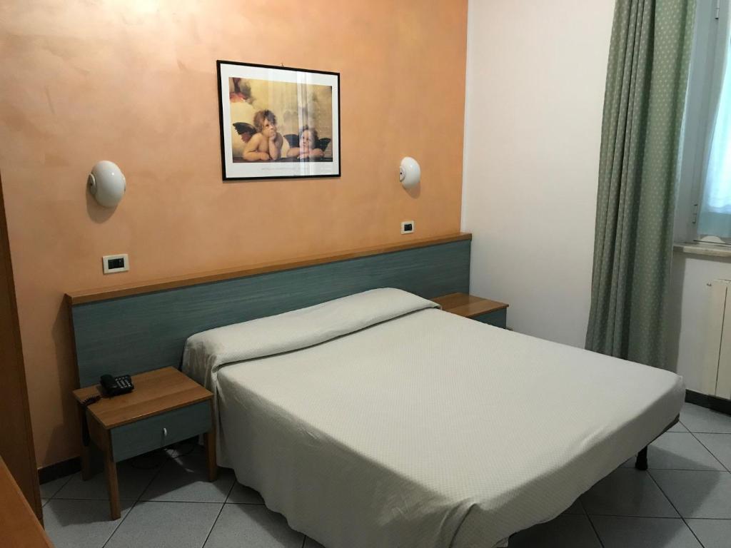 sypialnia z łóżkiem i zdjęciem na ścianie w obiekcie Hotel Amico Fritz w mieście Livorno