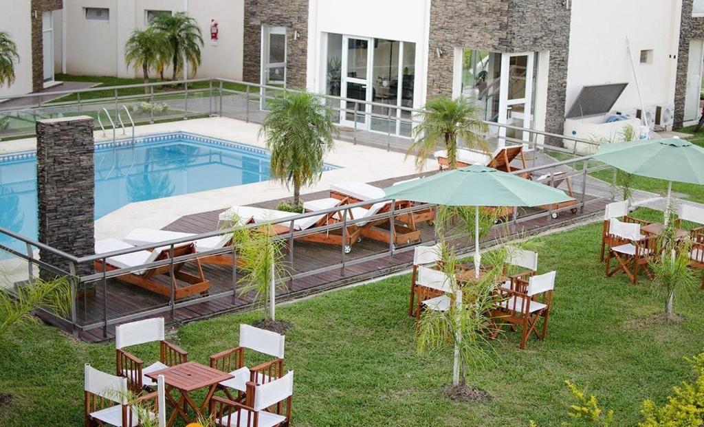 un patio con mesas y sombrillas junto a una piscina en Altos de Alem en Federación