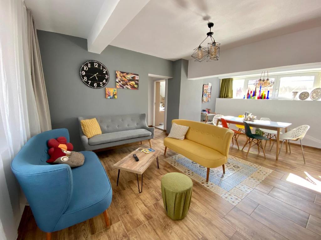 a living room with blue and yellow furniture and a table at Dominic Apartment Unirii Square in Timişoara
