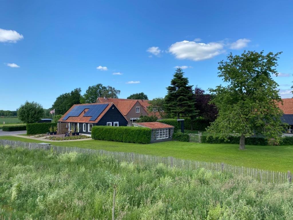 una casa con una valla y un campo de hierba en Bed & Breakfast Bed in Brabant Veghel, en Veghel