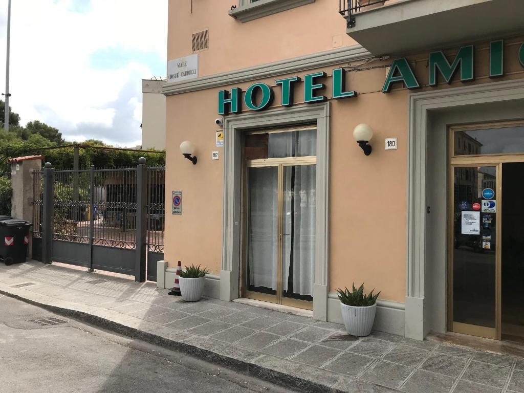 a hotel entrance with plants in front of a building at Hotel Amico Fritz in Livorno