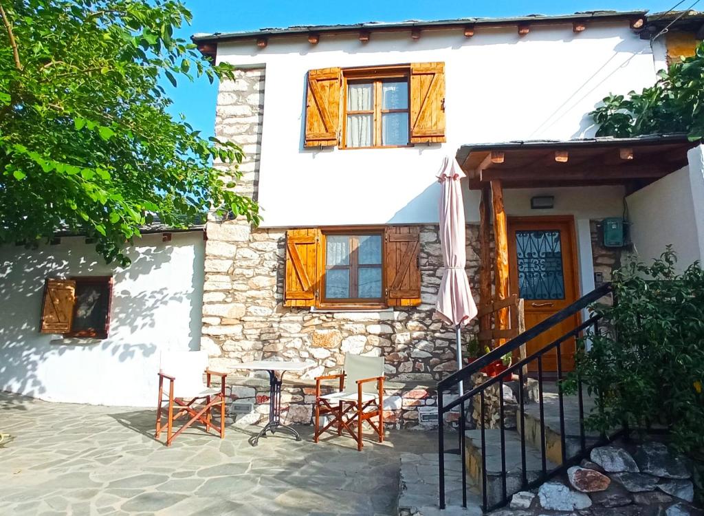 a house with a table and chairs in front of it at Linos Traditional Cottage in Theológos