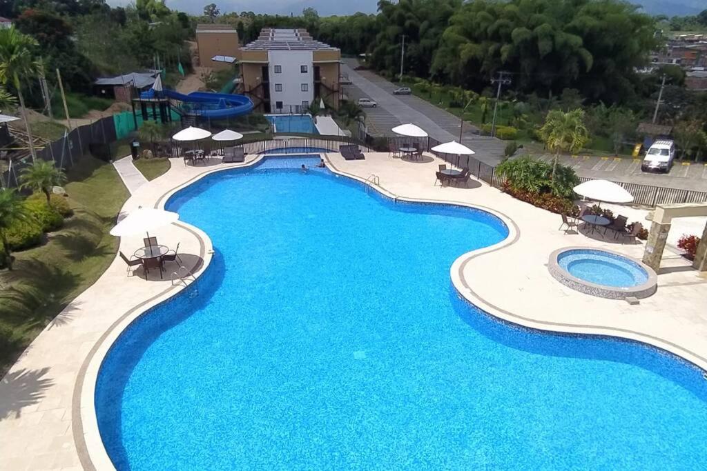 an overhead view of a swimming pool at a resort at APTO WIFI+ AIRE AC +PISCINAS +JACUZZI +TOBOGAN+BBQ in La Tebaida