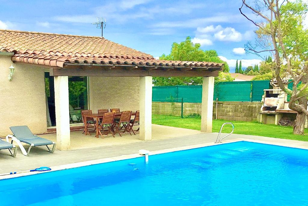 uma piscina em frente a uma casa com um gazebo em Résidence Alpha Centauri em Carcassonne