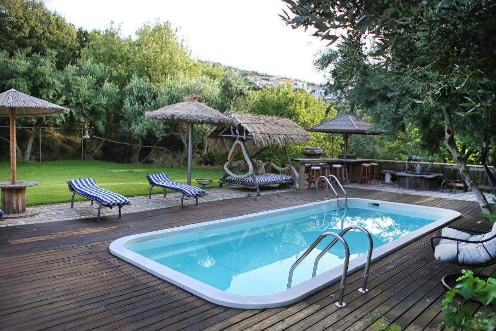 a swimming pool on a deck with chairs and a table at Captain Ikaros in Agios Kirykos