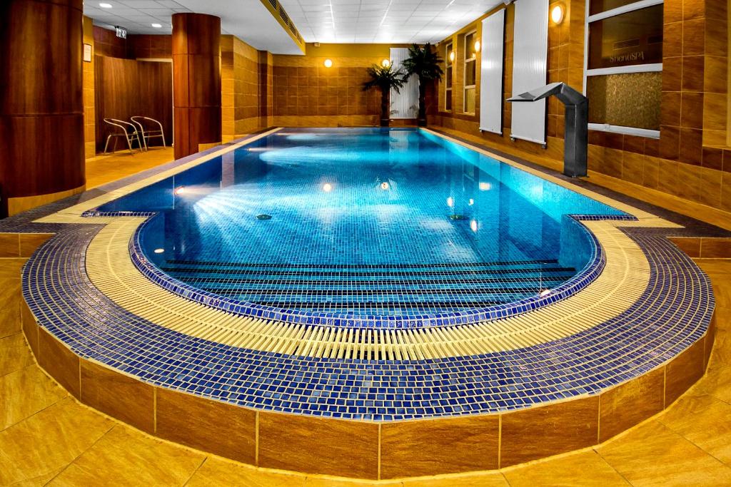a large swimming pool in a hotel room with a poolvisor at Grand Royal Hotel in Poznań
