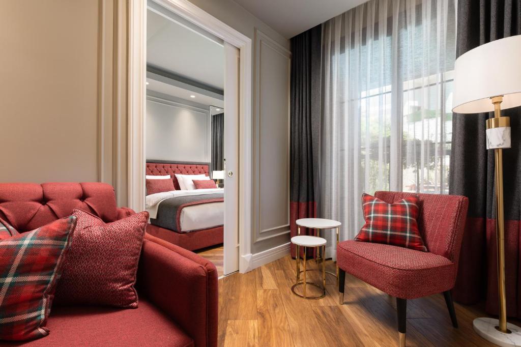 a hotel room with a red couch and a bed at Motif Hotel Çeşme in Çeşme