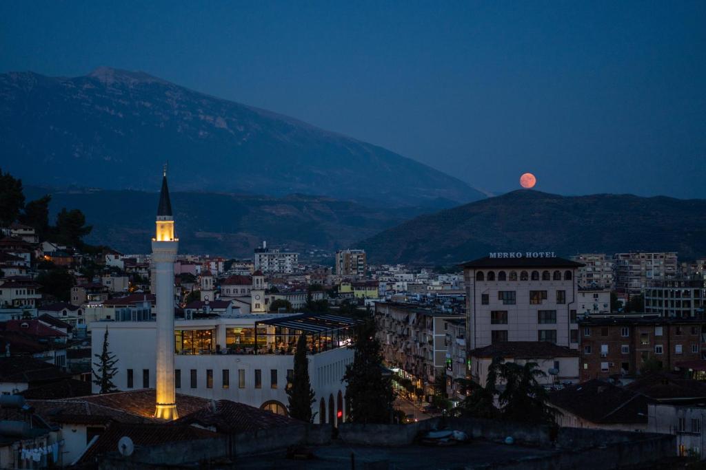 a view of a city with a clock tower at night at Hotel Borklad in Berat