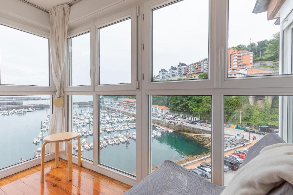 sala de estar con ventanas grandes con vistas al puerto deportivo en Portua - Baskey Rentals en Mutriku