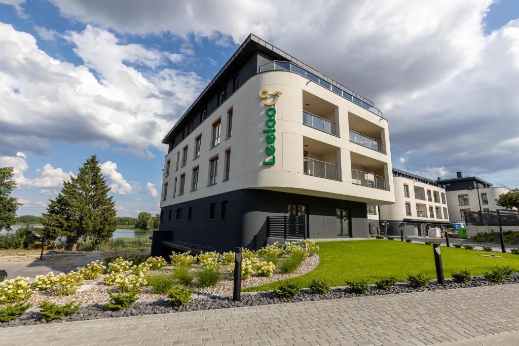 a large white building with a green sign on it at Leeloo in Człuchów