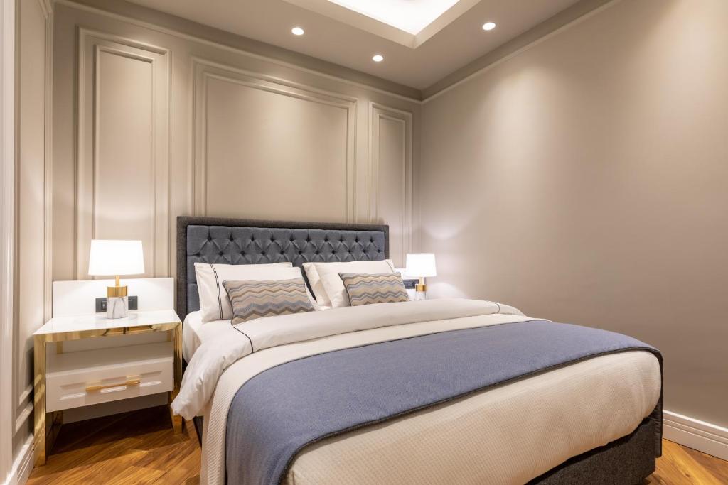 a bedroom with a large bed with a blue blanket at Motif Hotel Çeşme in Çeşme