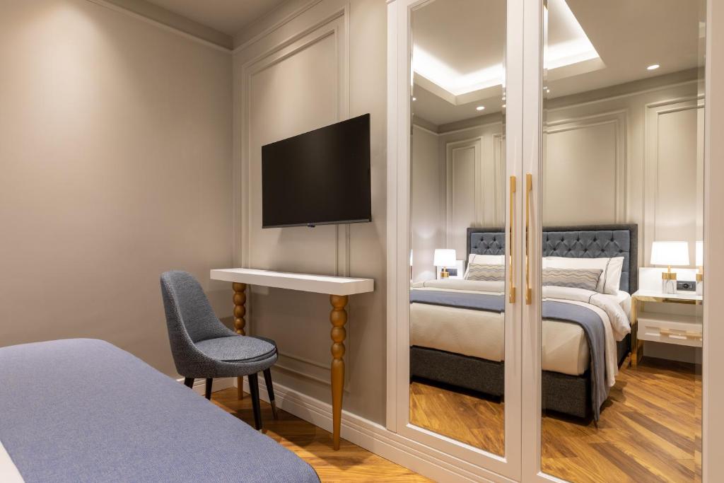 a bedroom with a bed and a tv on the wall at Motif Hotel Çeşme in Çeşme
