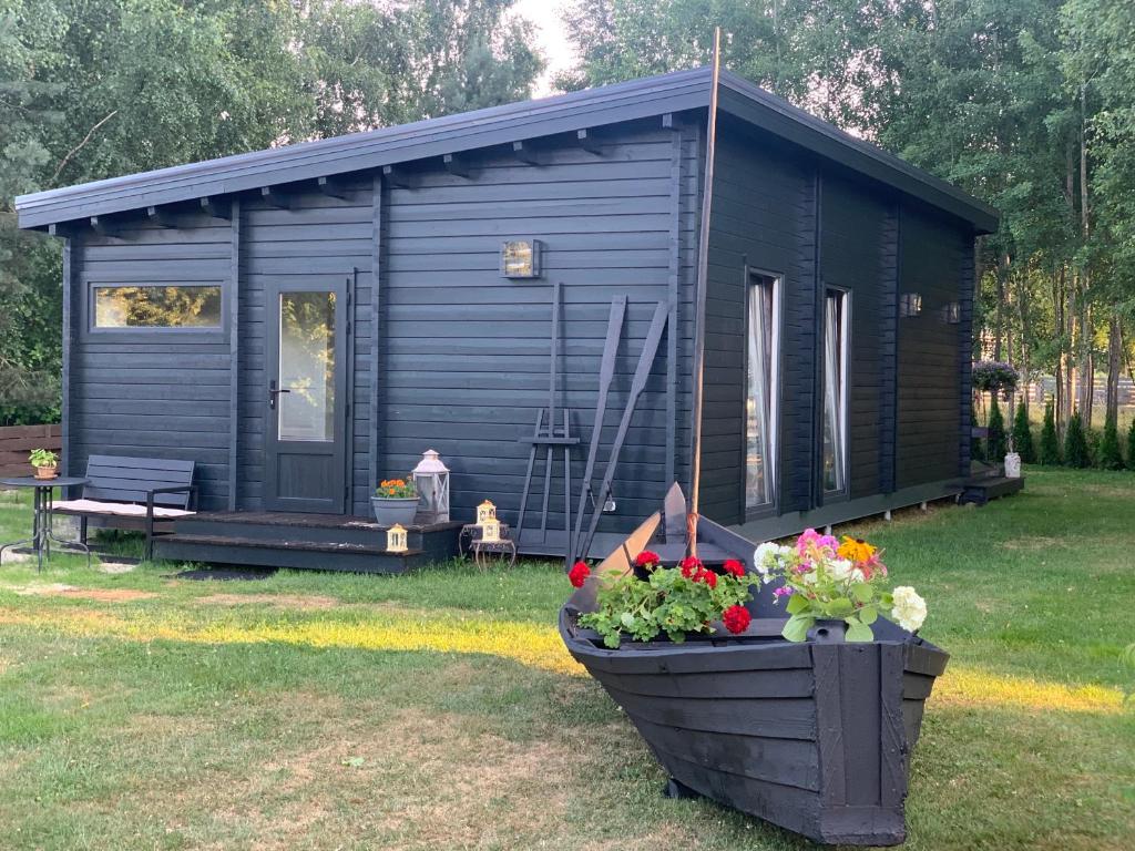 a blue cabin with a flower pot in front of it at Māja pie Ziedu laivas in Plieņciems