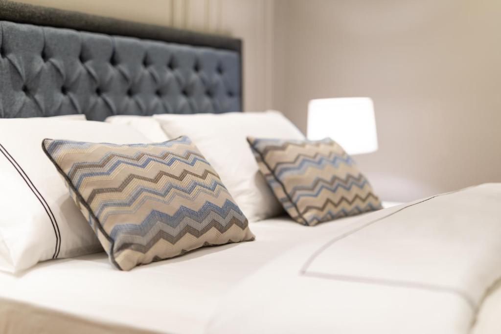 a white bed with two pillows on top of it at Motif Hotel Çeşme in Çeşme