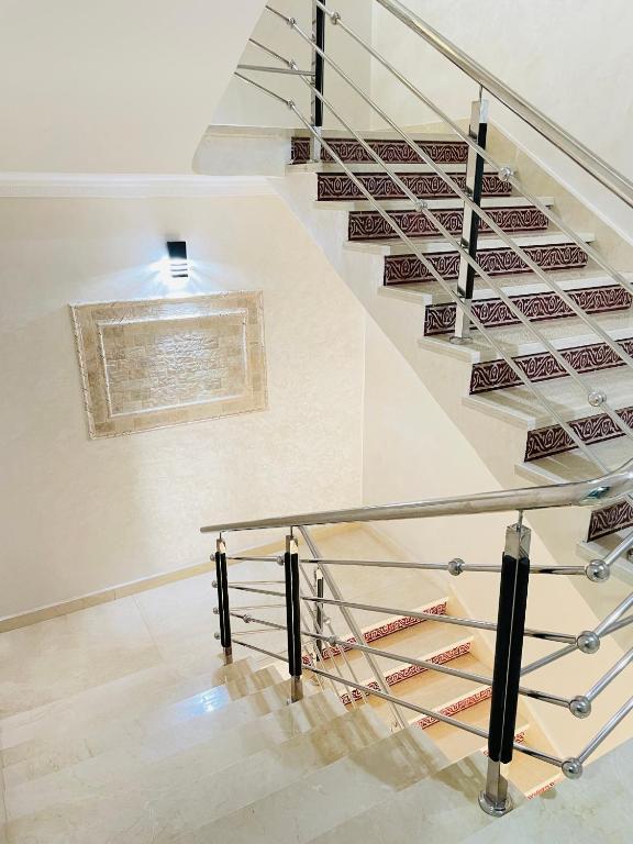 a staircase in a building with a glass railing at Laguna City Apartments in Nador