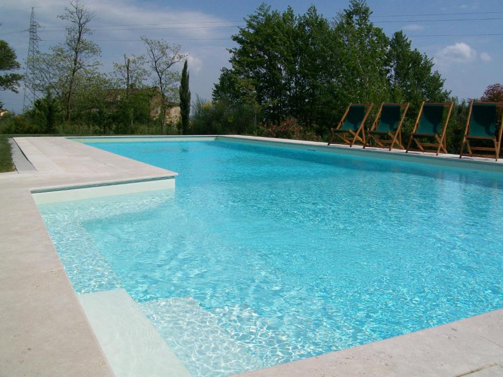 a large swimming pool with chairs in a yard at Casa Fontanino in Altopascio