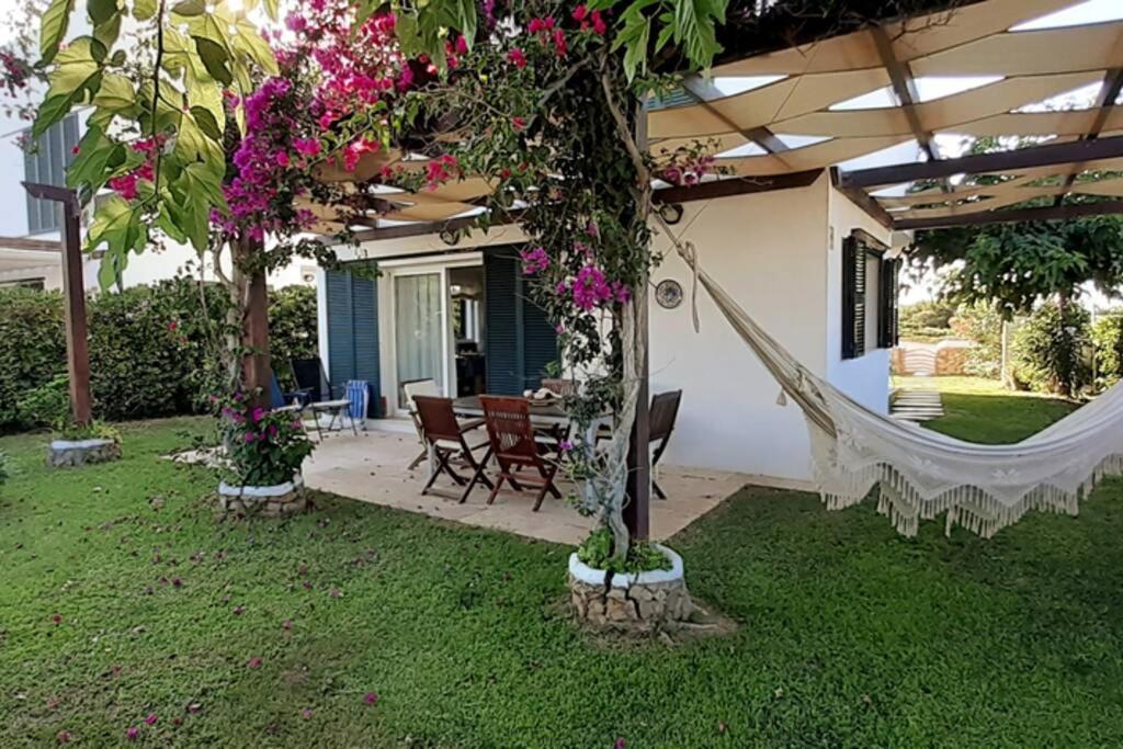 a house with a garden with a mirror in the yard at Villa SA CALMA ESVENTADA - Relax y confort a sólo 5 minutos de la playa in Es Mercadal