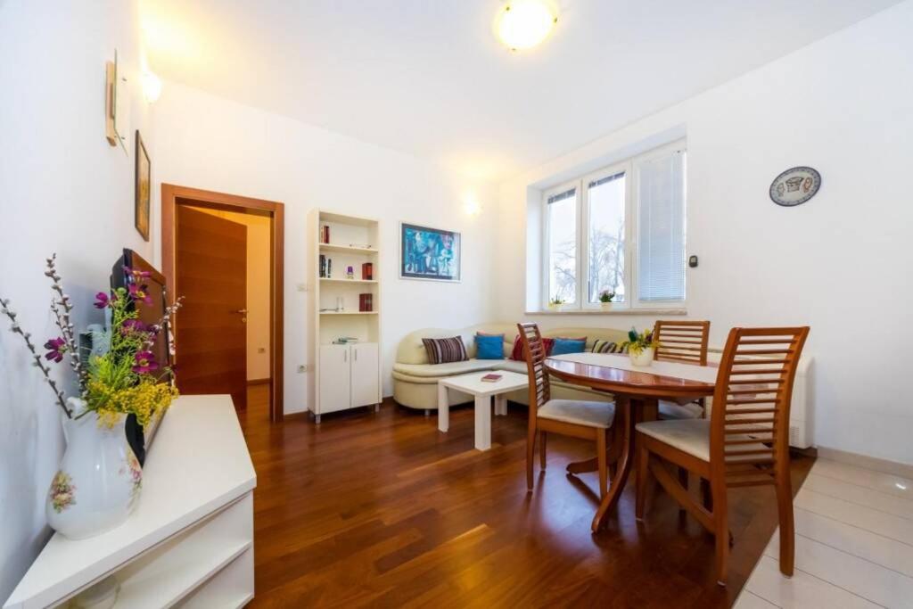 een woonkamer met een tafel en stoelen en een bank bij Sea Organ Apartment Zadar in Zadar