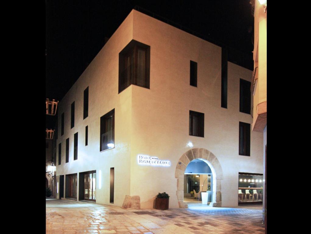 un grand bâtiment avec une arche en face dans l'établissement Hotel Raval de la Mar, à Vila-seca