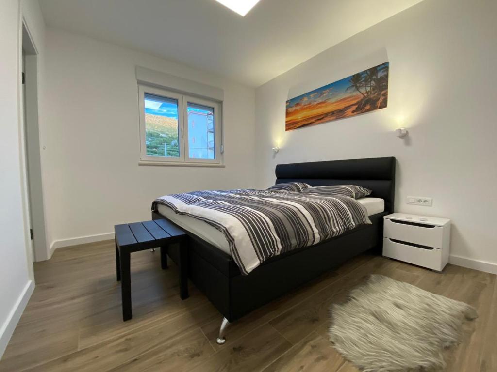 a bedroom with a bed and a window and a rug at Apartment Lida in Podstrana