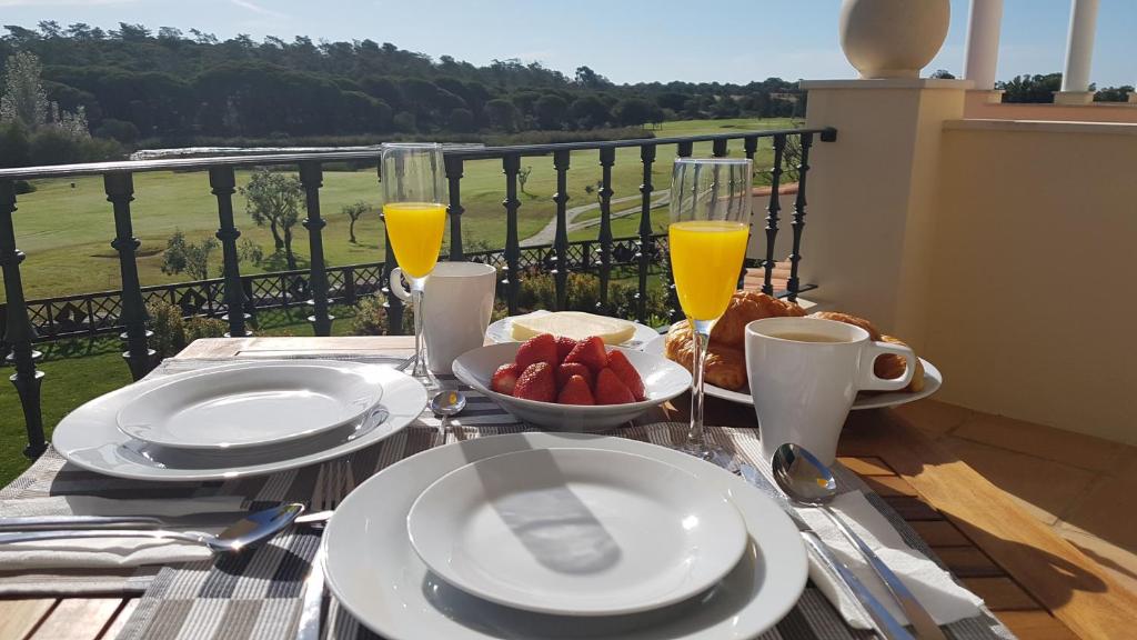 a table with plates of food and glasses of orange juice at Quinta Formosa Villa in Quinta do Lago