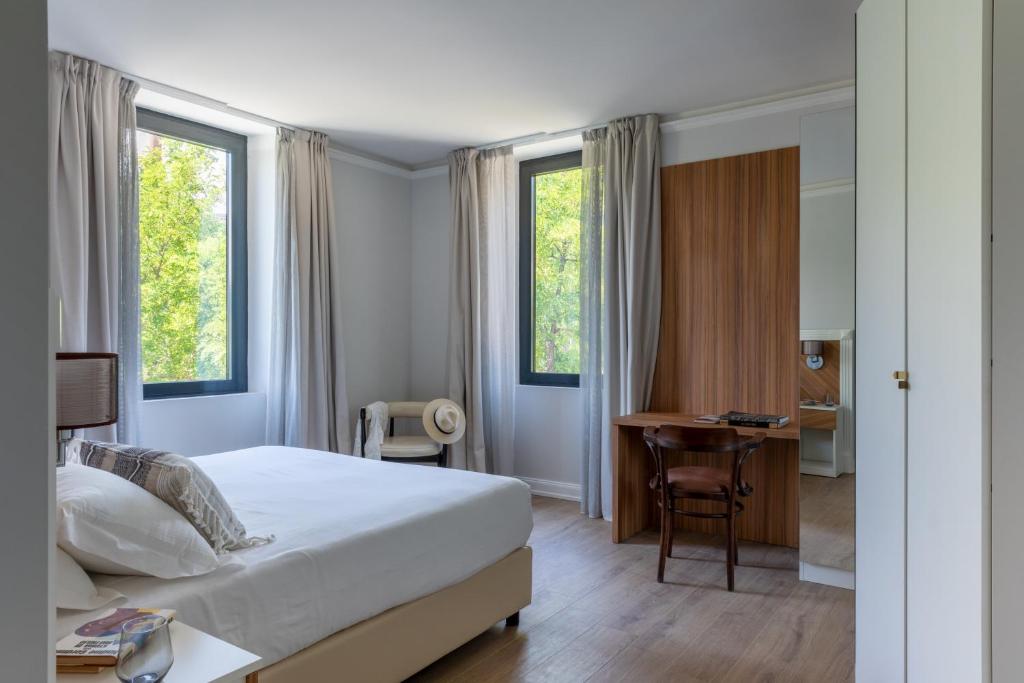 a bedroom with a bed and a desk and windows at Livia Valeria Palace in Rome