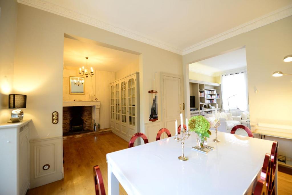 a dining room and living room with a table and chairs at Le Twelve in Angoulême