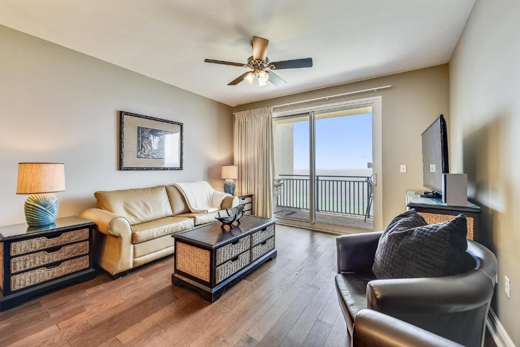 a living room with a couch and a tv at Sterling Breeze #1702 by Book That Condo in Panama City Beach