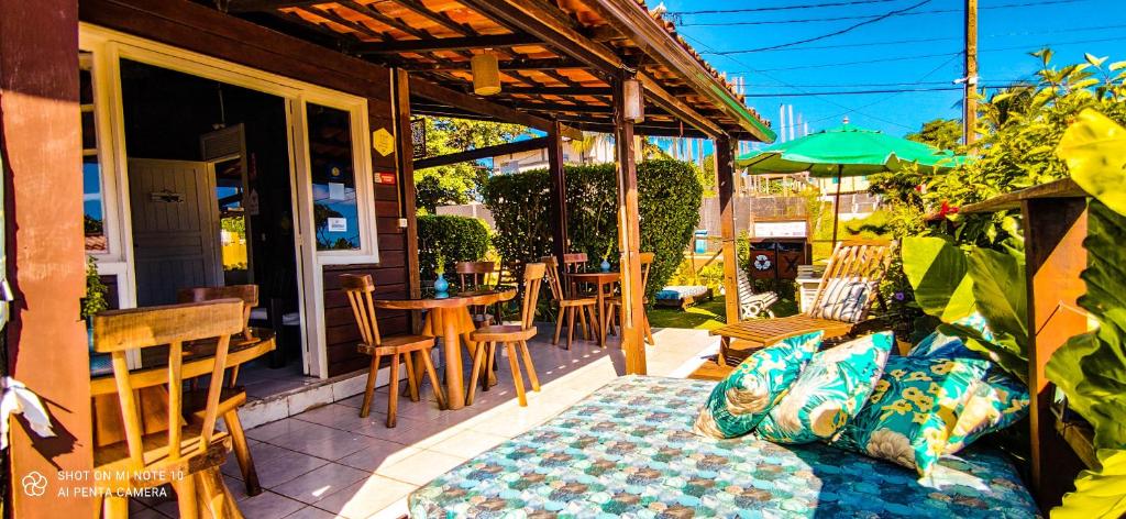 a patio with a table and chairs and an umbrella at Pousada Alamoa in Fernando de Noronha