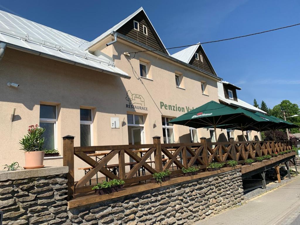 un restaurante con una valla de madera y un edificio en Penzion a Restaurace Vyhlídka en Železná Ruda