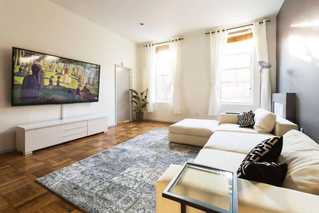 a living room with a couch and a flat screen tv at 4 Bedroom NYC Apartment in New York