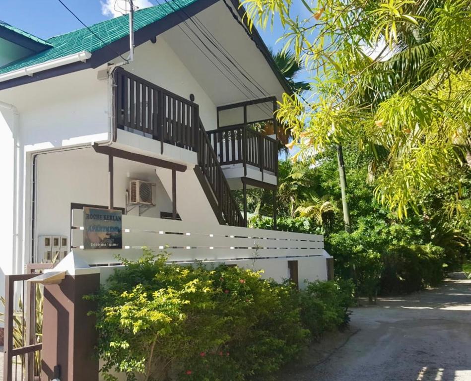 Casa blanca con escalera y balcón en Roche Kerlan Apartments, en Anse Possession