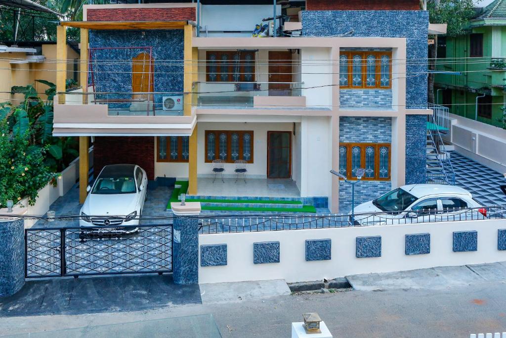 a house with two cars parked in front of it at Belljem Homes -your own private resort -1 BHK FF in Trichūr