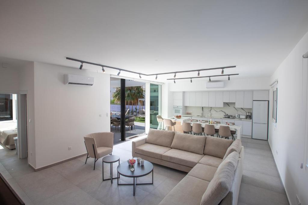 a living room with a couch and a table at Kube Luxury Villas in Ayia Napa