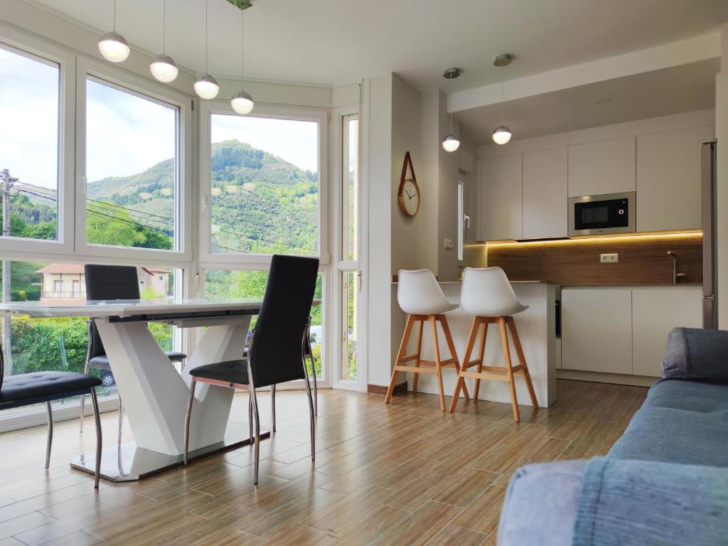 een keuken en een woonkamer met een tafel en stoelen bij LA CASITA DEL NORTE in Marrón