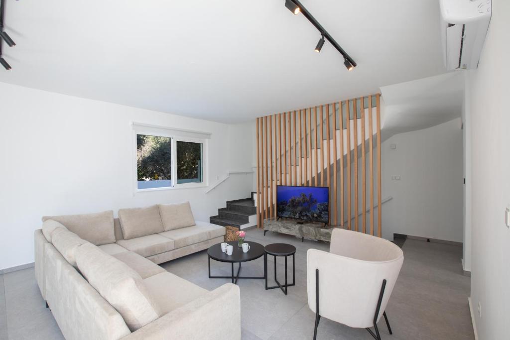 a living room with a couch and a tv at Kube Luxury Villas in Ayia Napa
