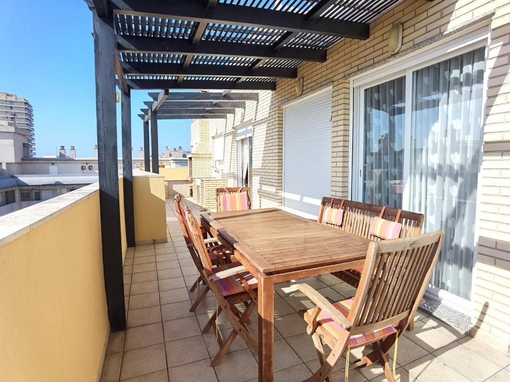 a wooden table and chairs on a balcony at Aguamarina in Peñíscola