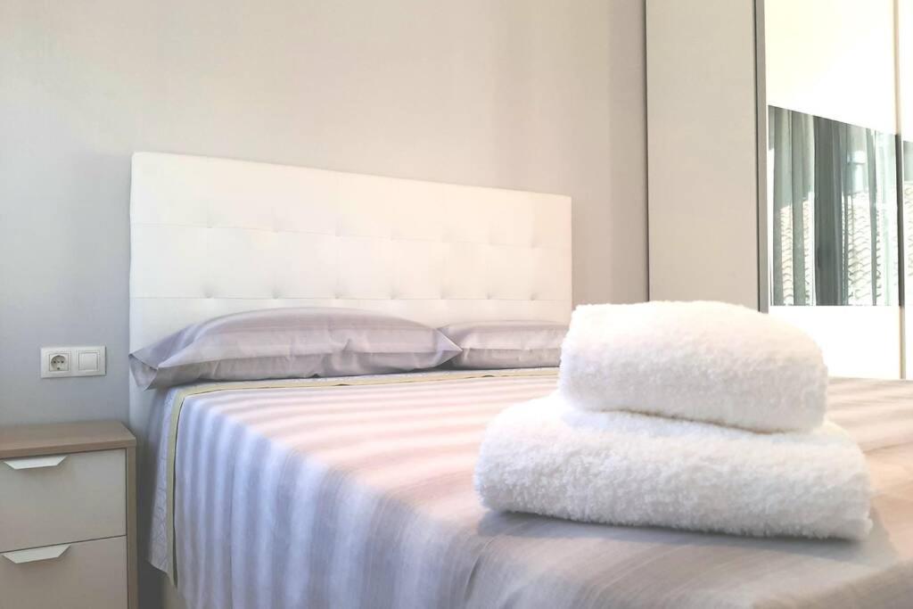 Una cama blanca con dos almohadas encima. en Ático en Monzón, en Monzón