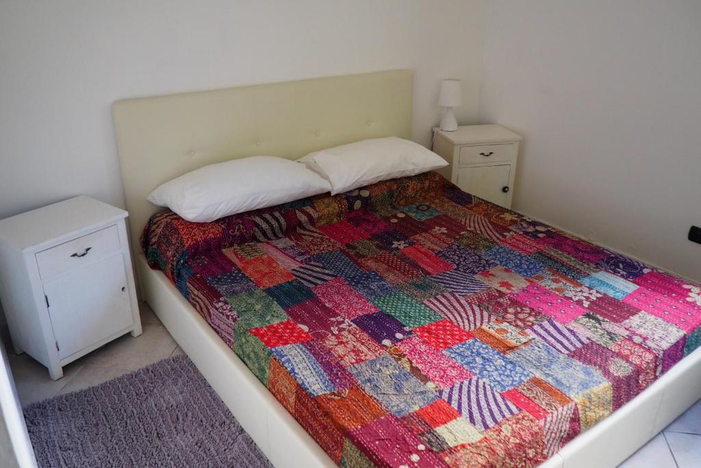 Un dormitorio con una cama con una colcha colorida. en Casa Morè Marina, en Carrara