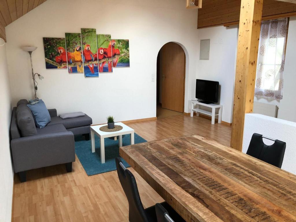 een woonkamer met een tafel en een bank bij Ferienwohnung Chirchgass in Meiringen
