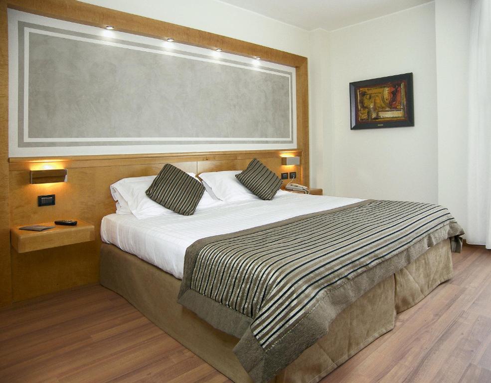 a bedroom with a large bed with a large window at Hotel President in Correggio