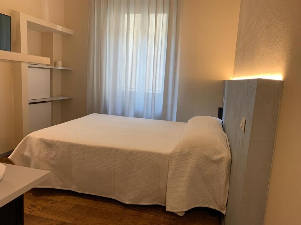 a bedroom with a white bed in a room at Albergo Roma in Buonconvento