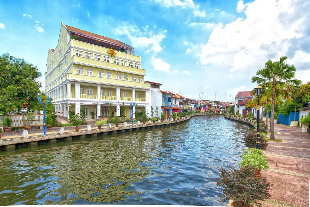 a building next to a river in a city at RC Hotel Melaka in Melaka